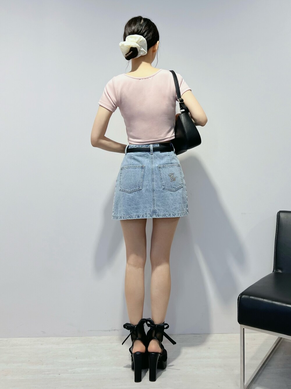 ブルー系のデニムスカート、ピンク系のTシャツ/カットソー、ブラウン系のショルダーバッグを着用したレディースの夏コーディネートの3枚目の写真