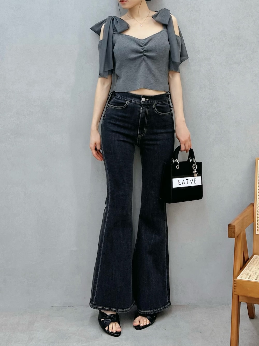 ブルー系のデニムパンツ、ブラック系のショルダーバッグ、グレー系のTシャツ/カットソーを着用したレディースの春コーディネートの4枚目の写真