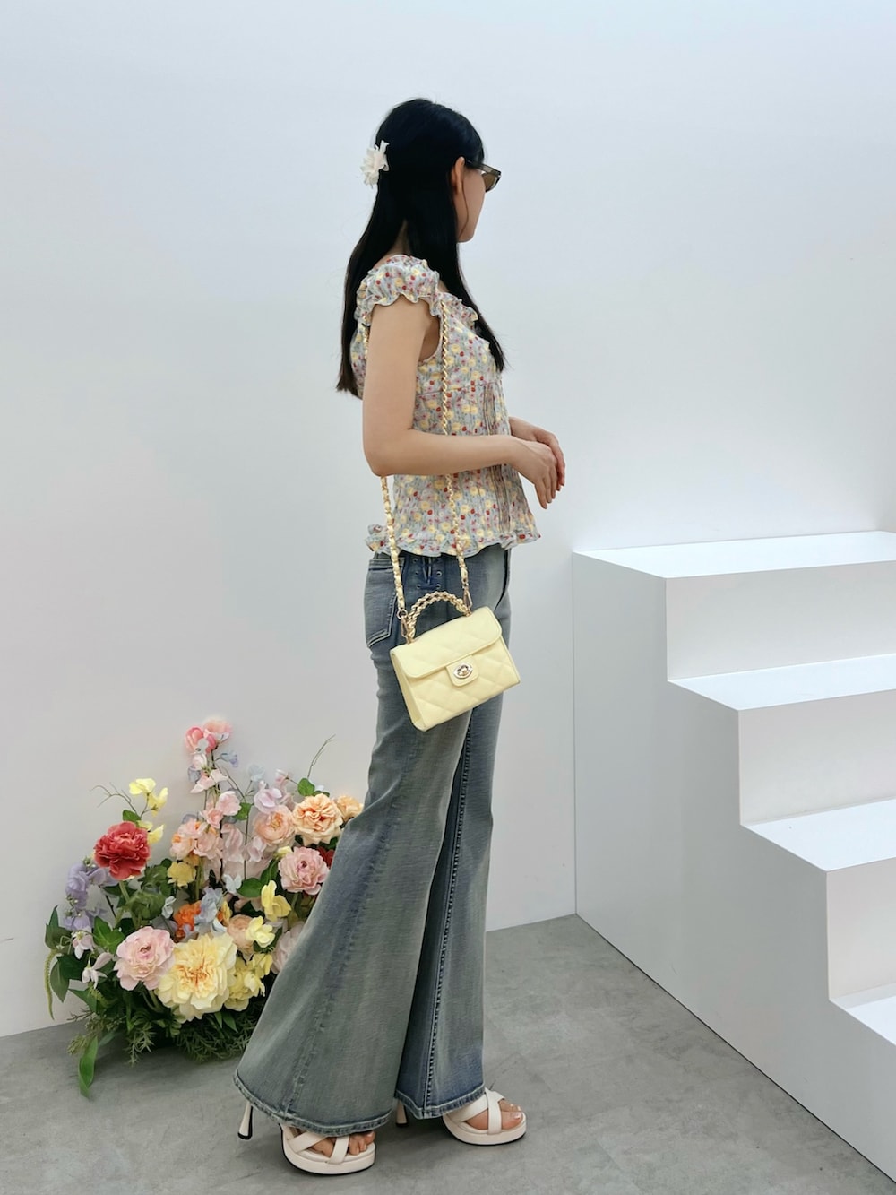 ブルー系のデニムパンツ、イエロー系のハンドバッグ、ブルー系のシャツ/ブラウスを着用したレディースの春コーディネートの2枚目の写真