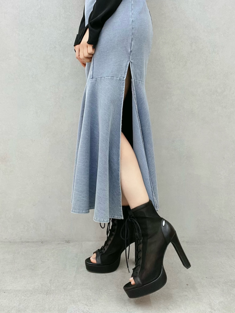 ブルー系のワンピース、ブラック系のTシャツ/カットソー、ブラック系のブーツを着用したレディースの春コーディネートの7枚目の写真