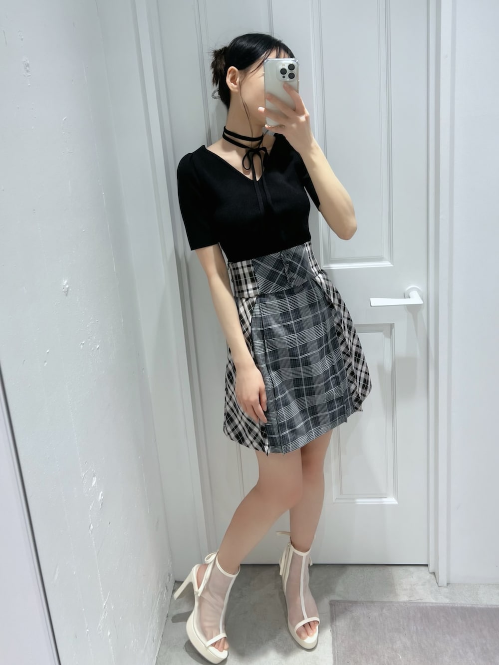 ブラック系のワンピース、ホワイト系のサンダルを着用したレディースの春コーディネートの2枚目の写真