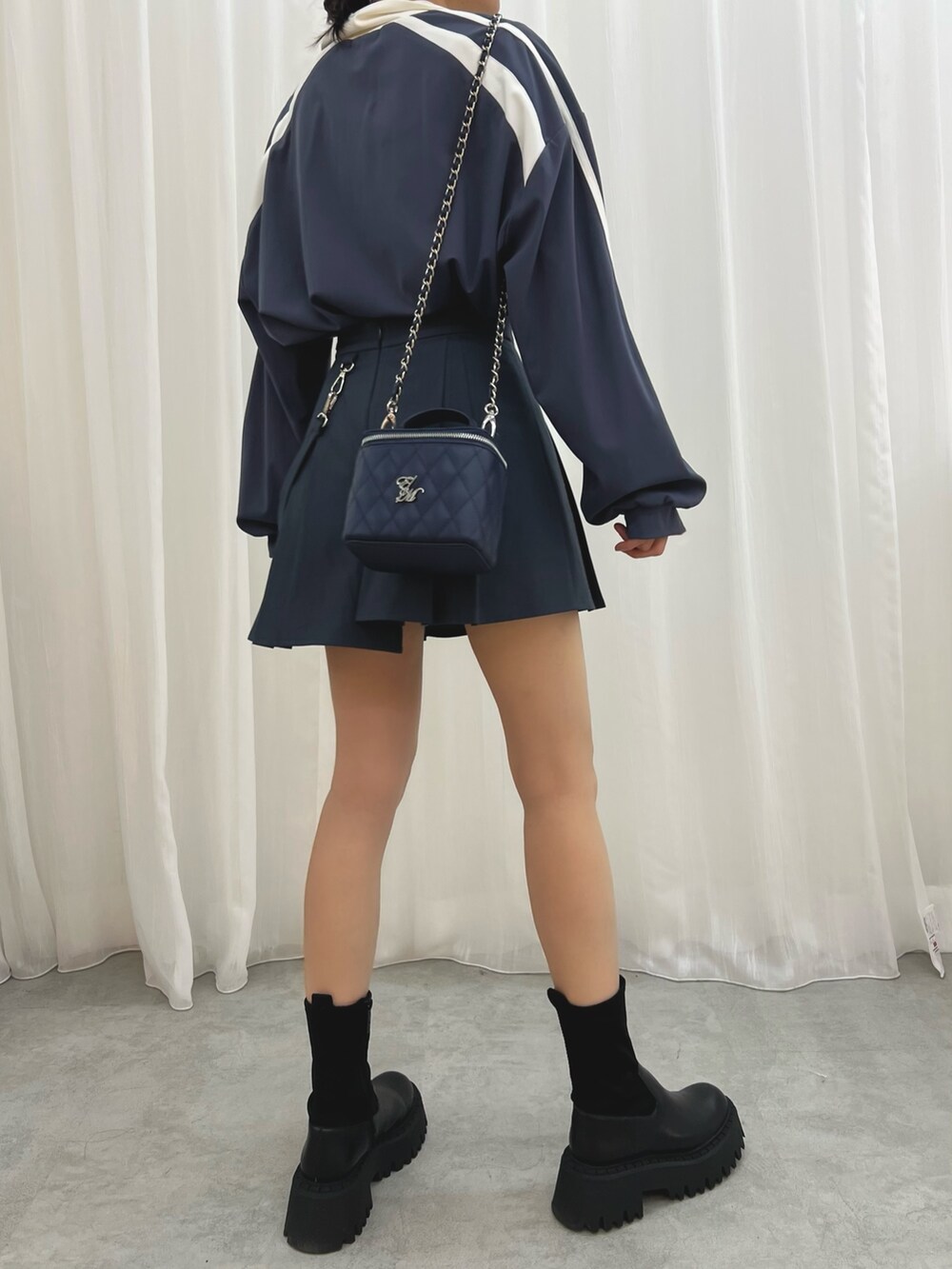 ブルー系のハンドバッグ、ブルー系のスカート、ブルー系のTシャツ/カットソーを着用したレディースの冬コーディネートの6枚目の写真