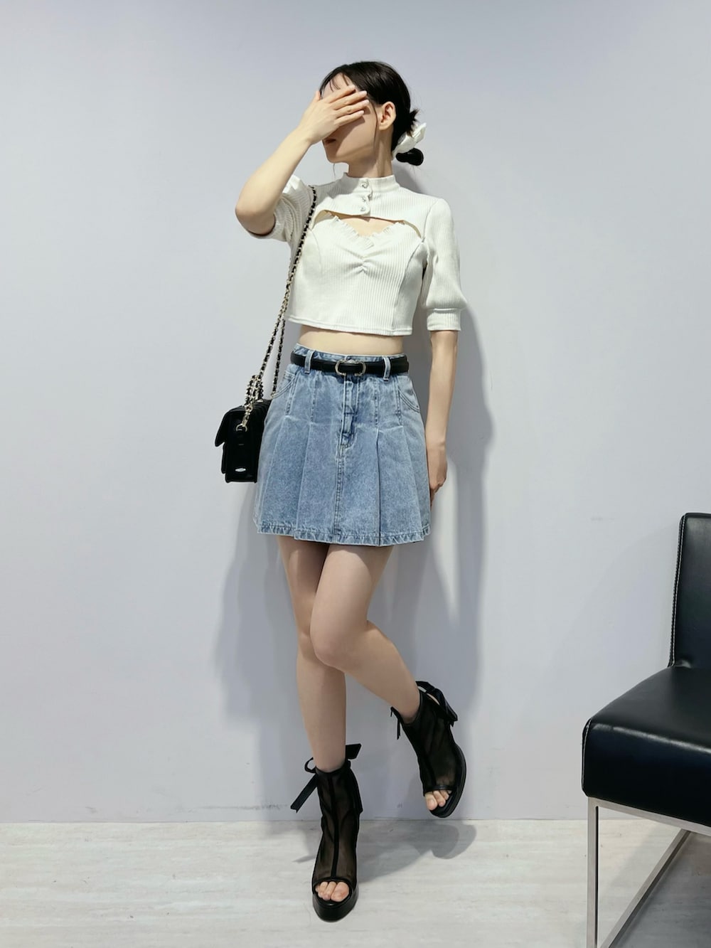 ブルー系のデニムスカート、ブラック系のサンダル、ホワイト系のTシャツ/カットソーを着用したレディースの夏コーディネートの2枚目の写真