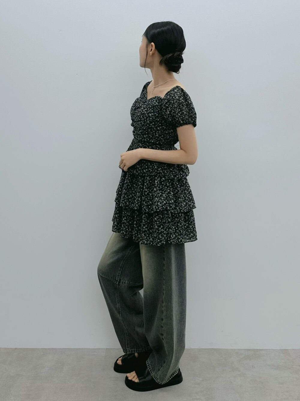 ブラック系のワンピース、ブルー系のデニムパンツ、シルバー系のネックレスを着用したレディースの夏コーディネートの3枚目の写真