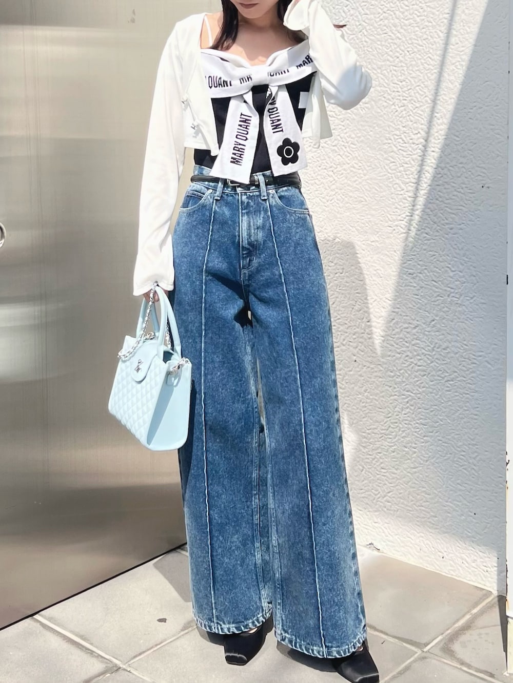ブラック系のワンピース、ホワイト系のTシャツ/カットソー、ブルー系のハンドバッグを着用したレディースの春コーディネートの2枚目の写真