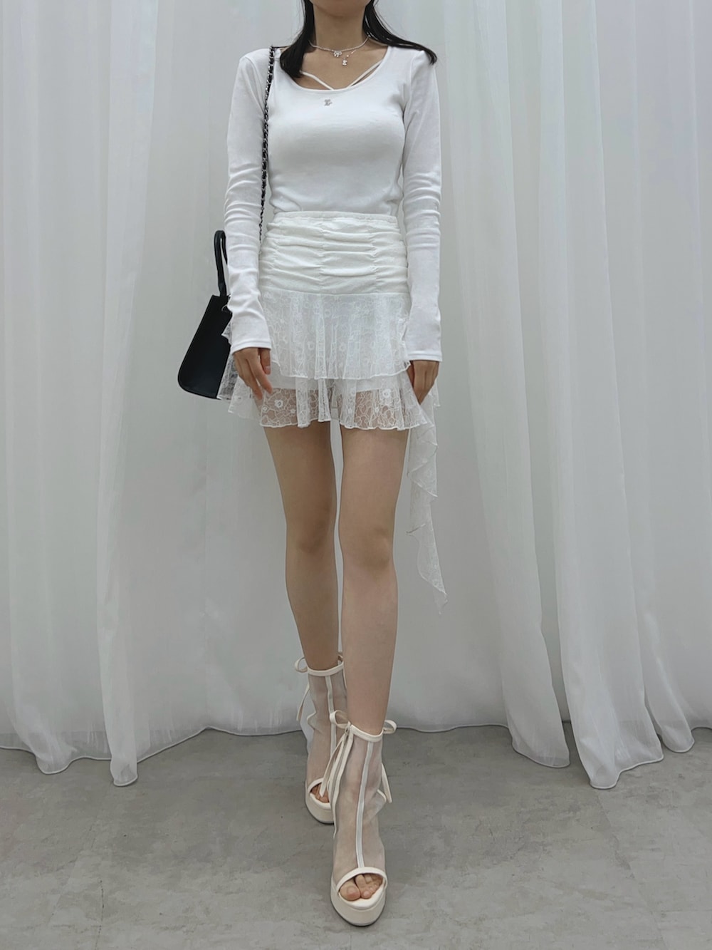 ホワイト系のスカート、ホワイト系のサンダル、ホワイト系のTシャツ/カットソーを着用したレディースの夏コーディネートの4枚目の写真