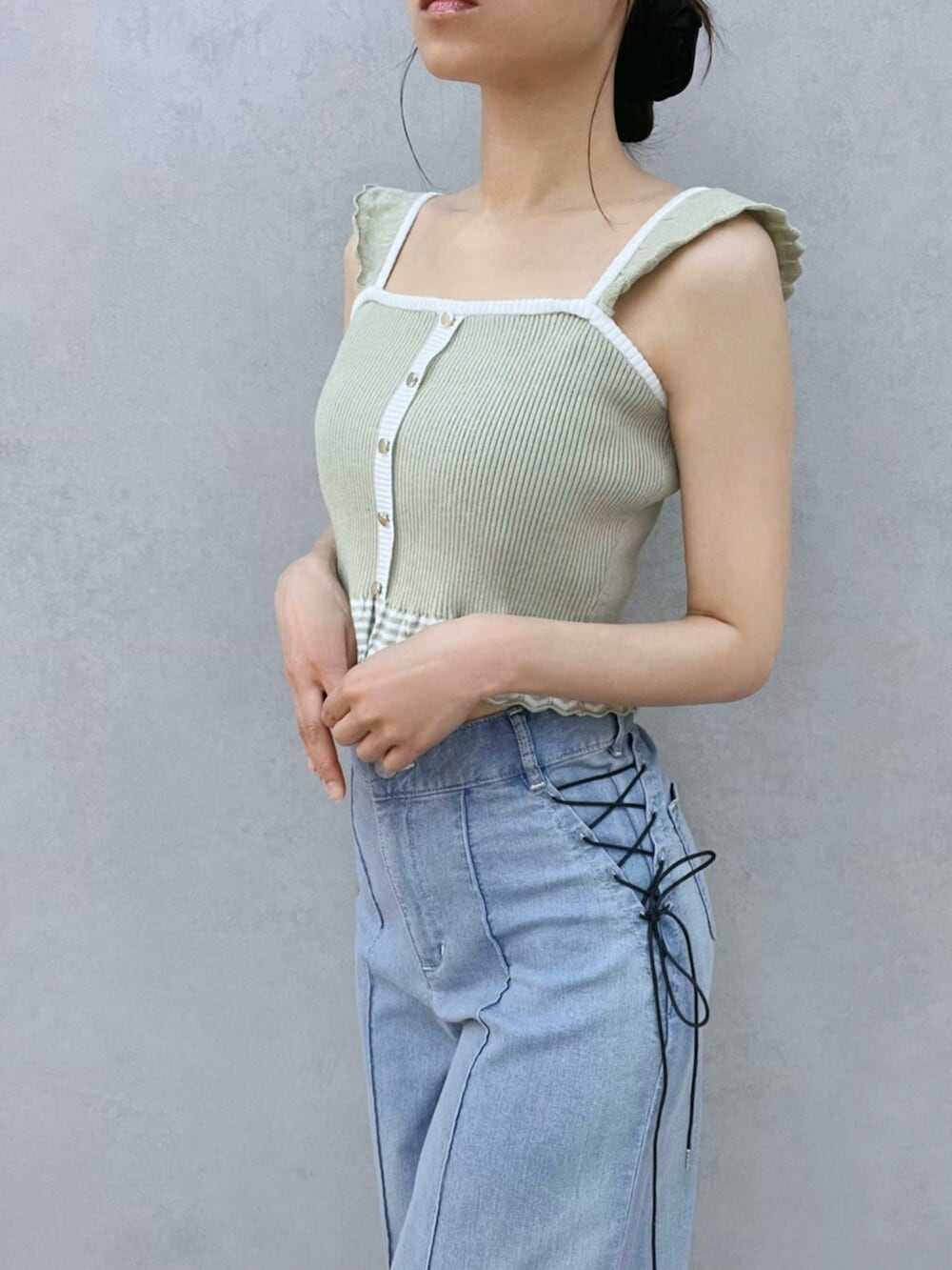 ホワイト系のサンダル、ブルー系のデニムパンツ、グリーン系のキャミソールを着用したレディースの夏コーディネートの9枚目の写真