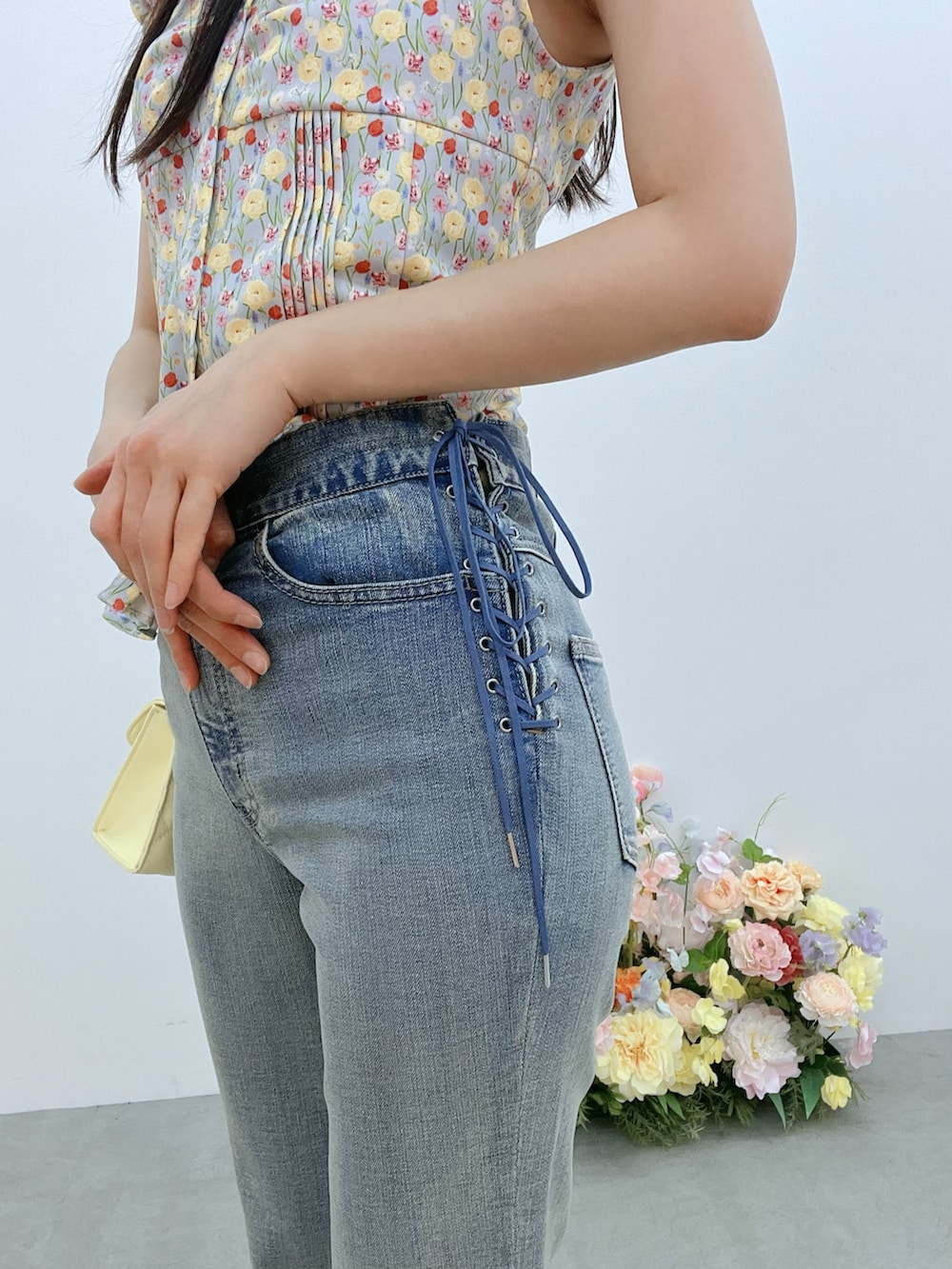 ブルー系のデニムパンツ、イエロー系のハンドバッグ、ブルー系のシャツ/ブラウスを着用したレディースの春コーディネートの6枚目の写真