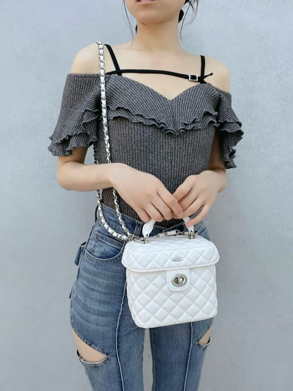 ブルー系のデニムパンツ、グレー系のTシャツ/カットソー、ホワイト系のハンドバッグを着用したレディースの夏コーディネートの6枚目の写真