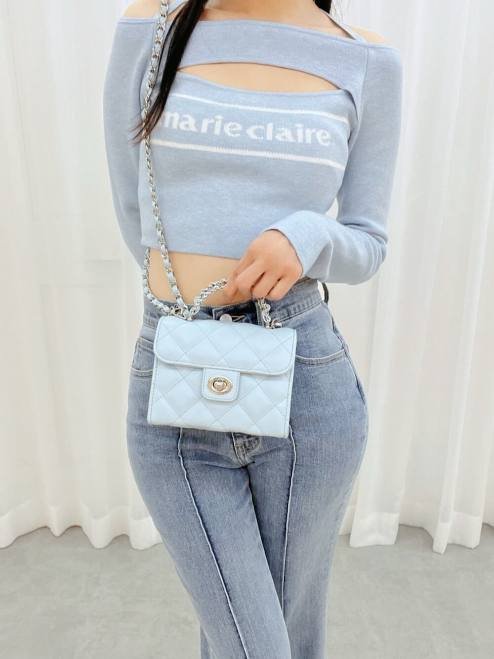 ホワイト系のブーツ、ブルー系のニット/セーター、ブルー系のデニムパンツを着用したレディースの冬コーディネートの6枚目の写真