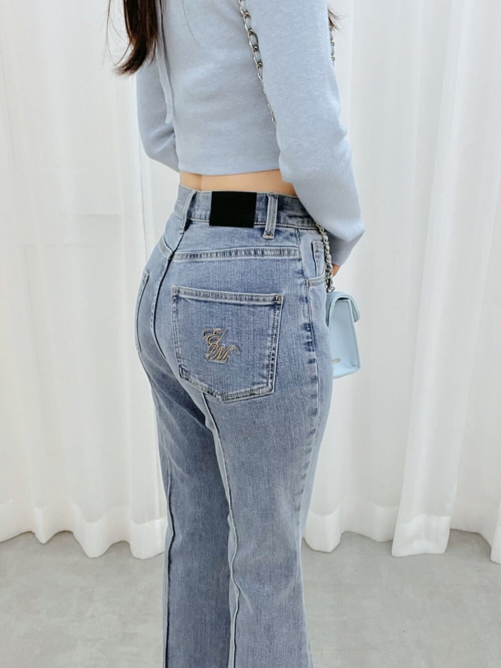 ホワイト系のブーツ、ブルー系のニット/セーター、ブルー系のデニムパンツを着用したレディースの冬コーディネートの4枚目の写真