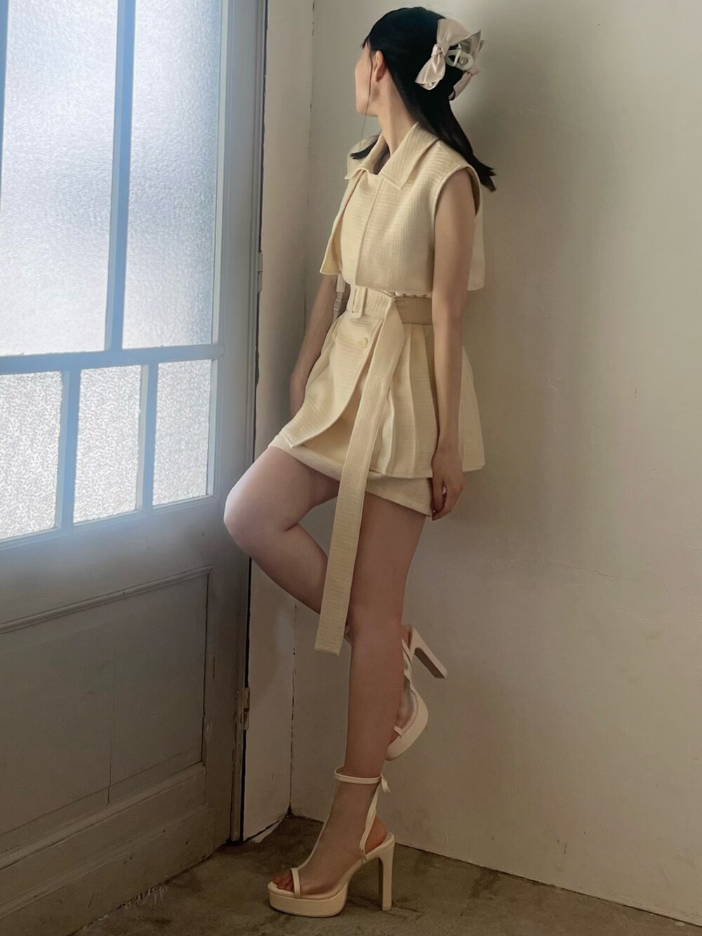 イエロー系のつなぎ/オールインワン、ホワイト系のサンダル、ピンク系のバレッタ/ヘアクリップを着用したレディースの春コーディネートの4枚目の写真