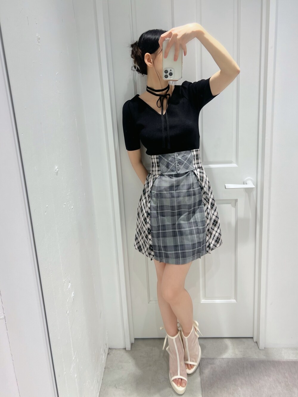 ブラック系のワンピース、ホワイト系のサンダルを着用したレディースの春コーディネートの4枚目の写真