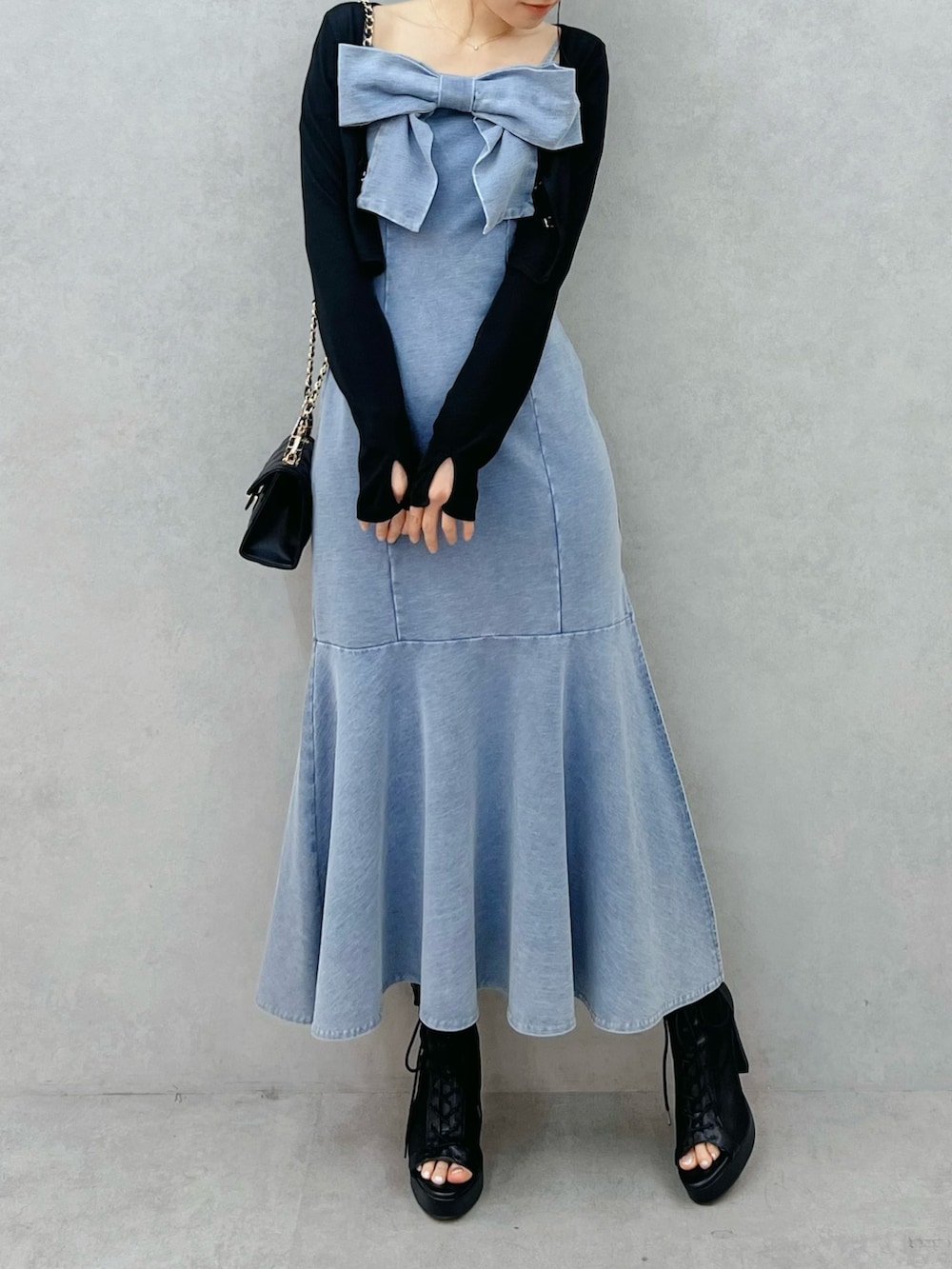 ブルー系のワンピース、ブラック系のTシャツ/カットソー、ブラック系のブーツを着用したレディースの春コーディネートの4枚目の写真