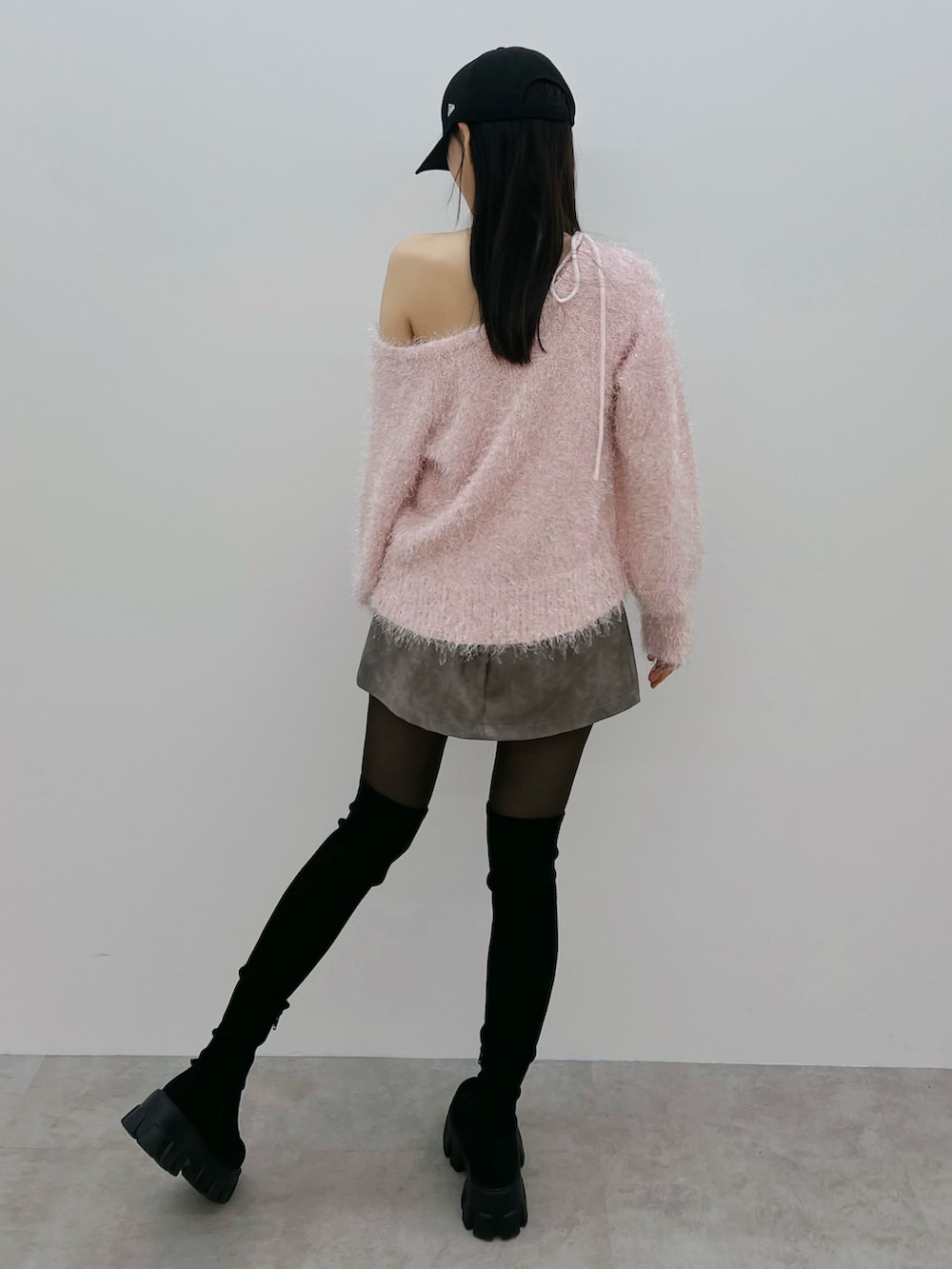 グレー系のスカート、ブラック系のブーツ、ピンク系のニット/セーターを着用したレディースの冬コーディネートの4枚目の写真