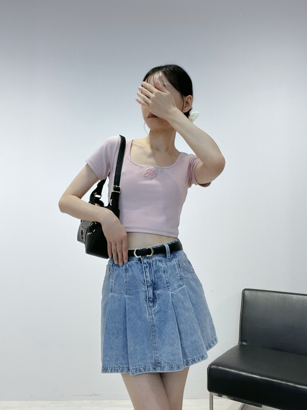 ブルー系のデニムスカート、ピンク系のTシャツ/カットソー、ブラウン系のショルダーバッグを着用したレディースの夏コーディネートの4枚目の写真