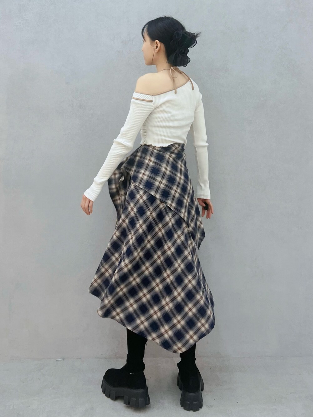 ブルー系のスカート、ホワイト系のTシャツ/カットソー、ブラック系のブーツを着用したレディースの秋コーディネートの3枚目の写真
