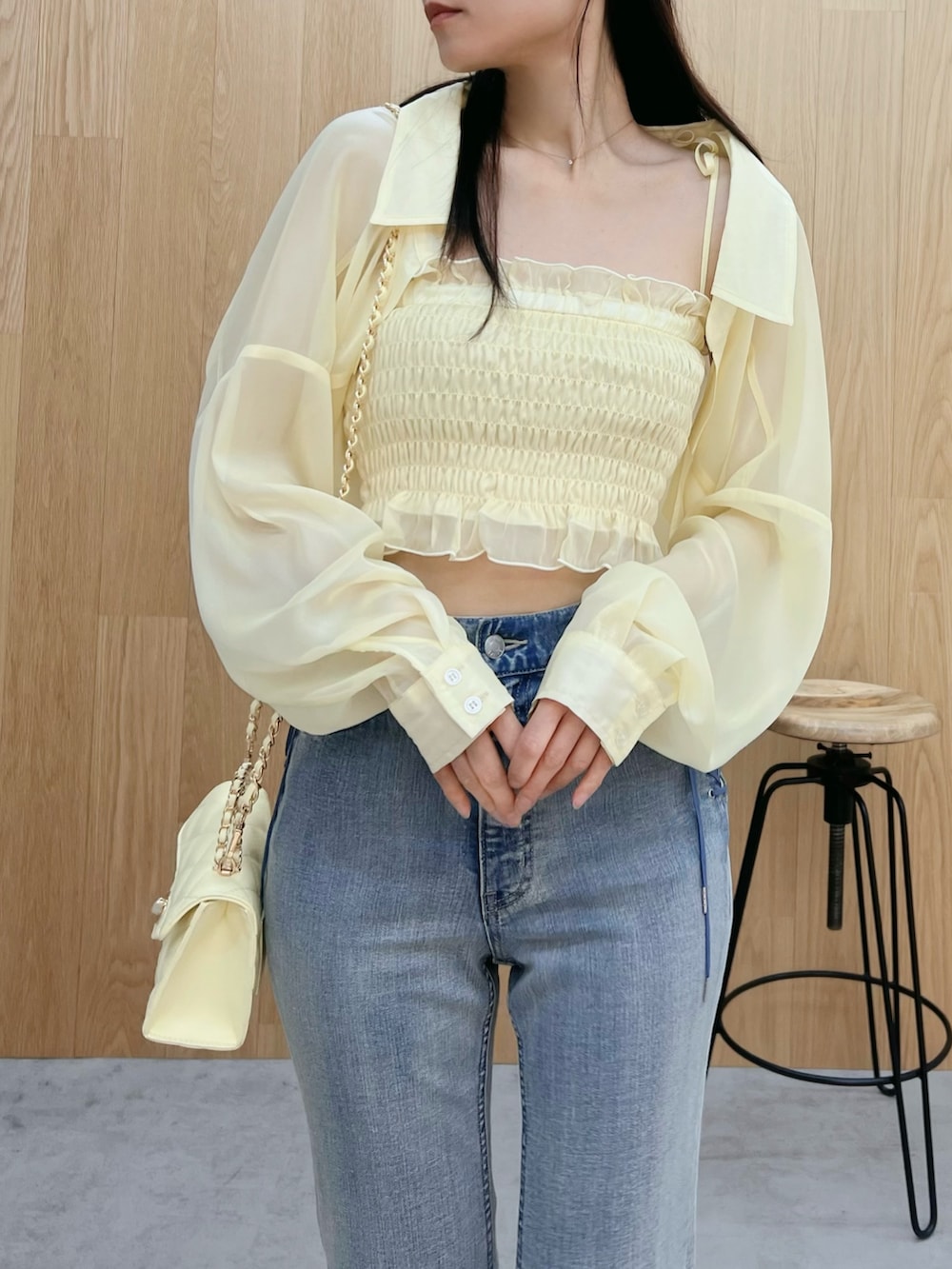 ホワイト系のサンダル、ブルー系のデニムパンツ、イエロー系のハンドバッグを着用したレディースの春コーディネートの5枚目の写真