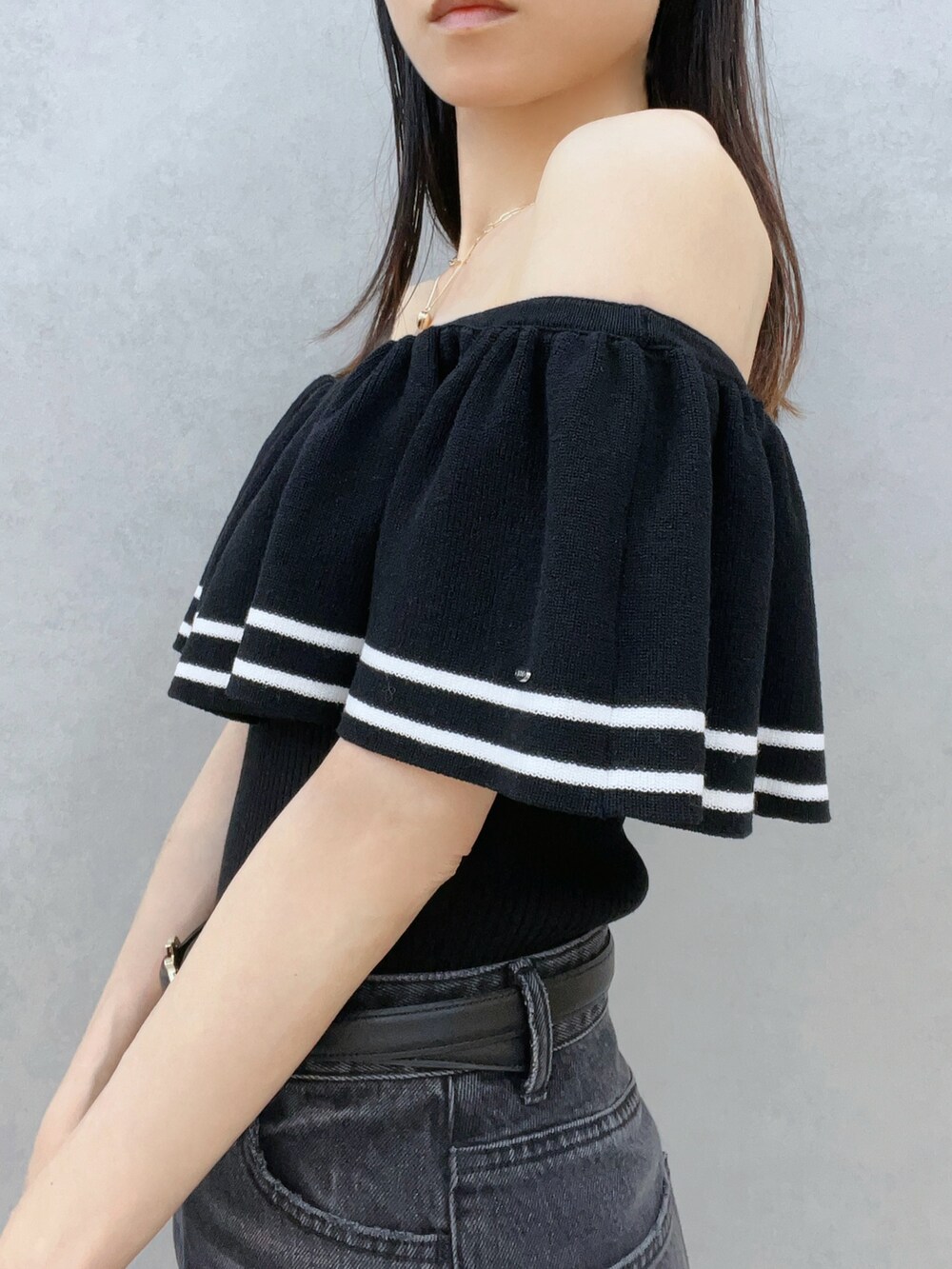 ブラック系のニット/セーター、ブラック系のサングラス、ブラック系のベルトを着用したレディースの夏コーディネートの6枚目の写真