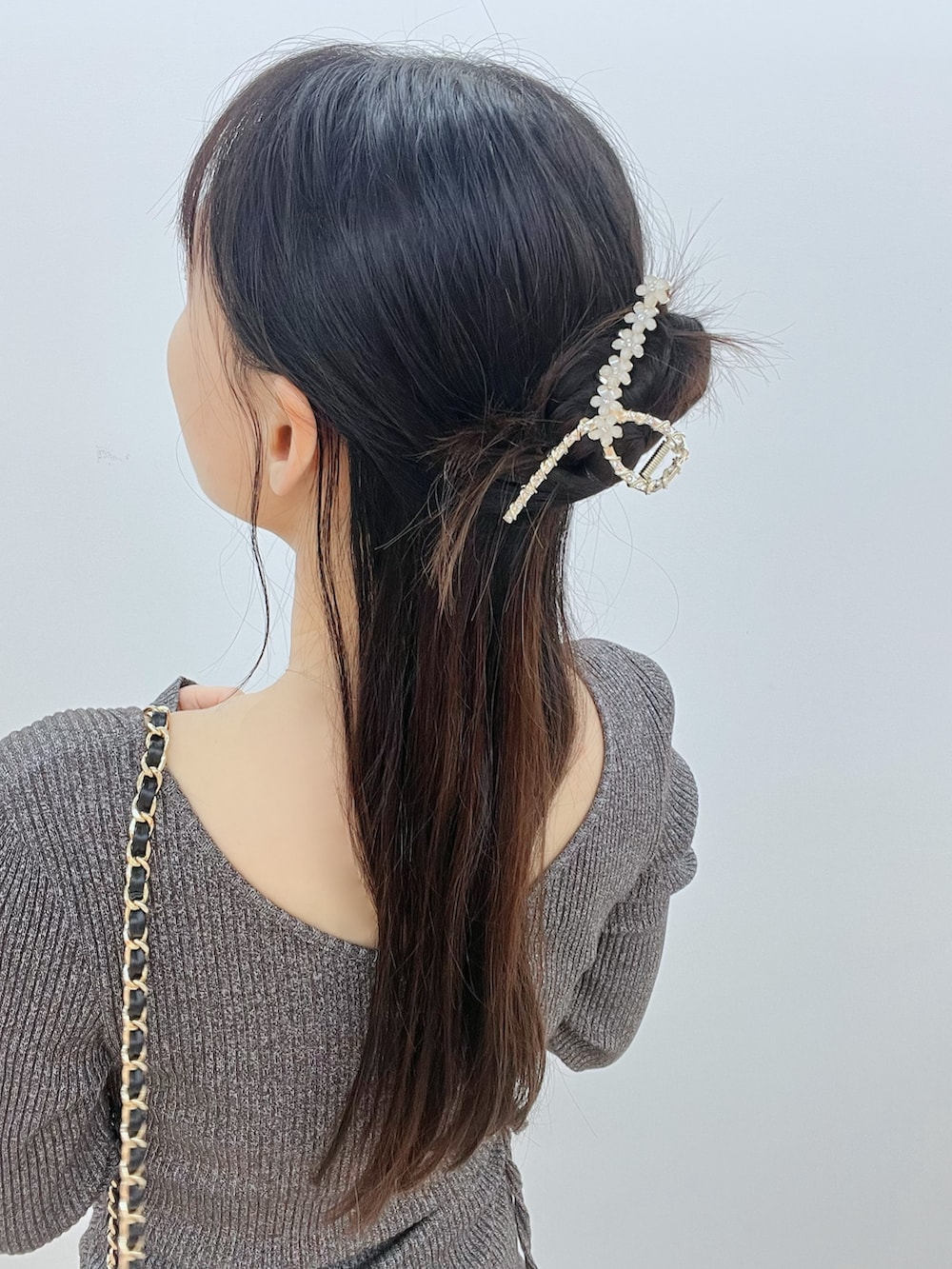 ブラック系のサンダル、グレー系のワンピース、ブラック系のハンドバッグを着用したレディースの春コーディネートの7枚目の写真