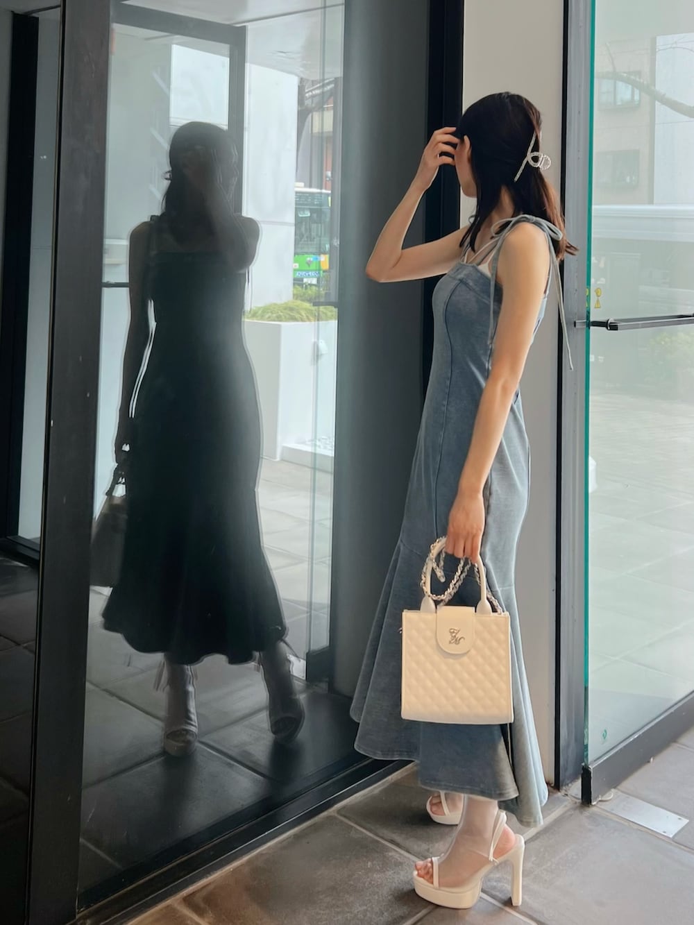 ブルー系のワンピース、ホワイト系のサンダル、ホワイト系のハンドバッグを着用したレディースの春コーディネートの4枚目の写真