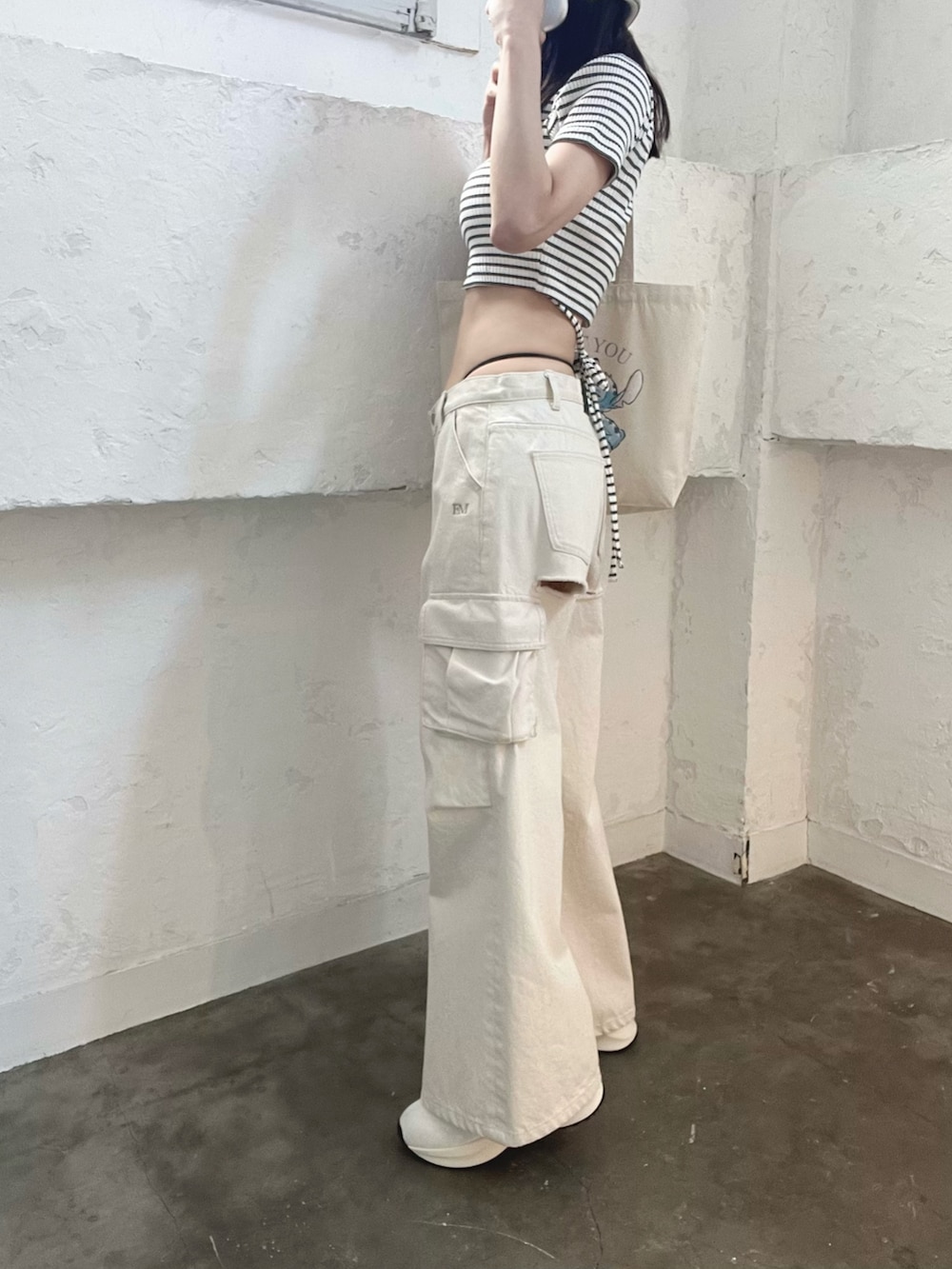 ホワイト系のデニムパンツ、その他のTシャツ/カットソー、ホワイト系のブーツを着用したレディースの春コーディネートの3枚目の写真