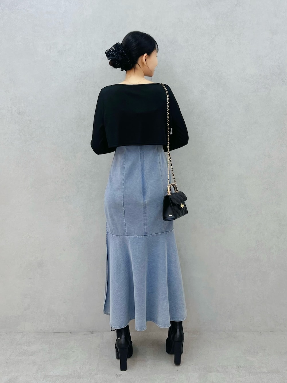 ブルー系のワンピース、ブラック系のTシャツ/カットソー、ブラック系のブーツを着用したレディースの春コーディネートの3枚目の写真