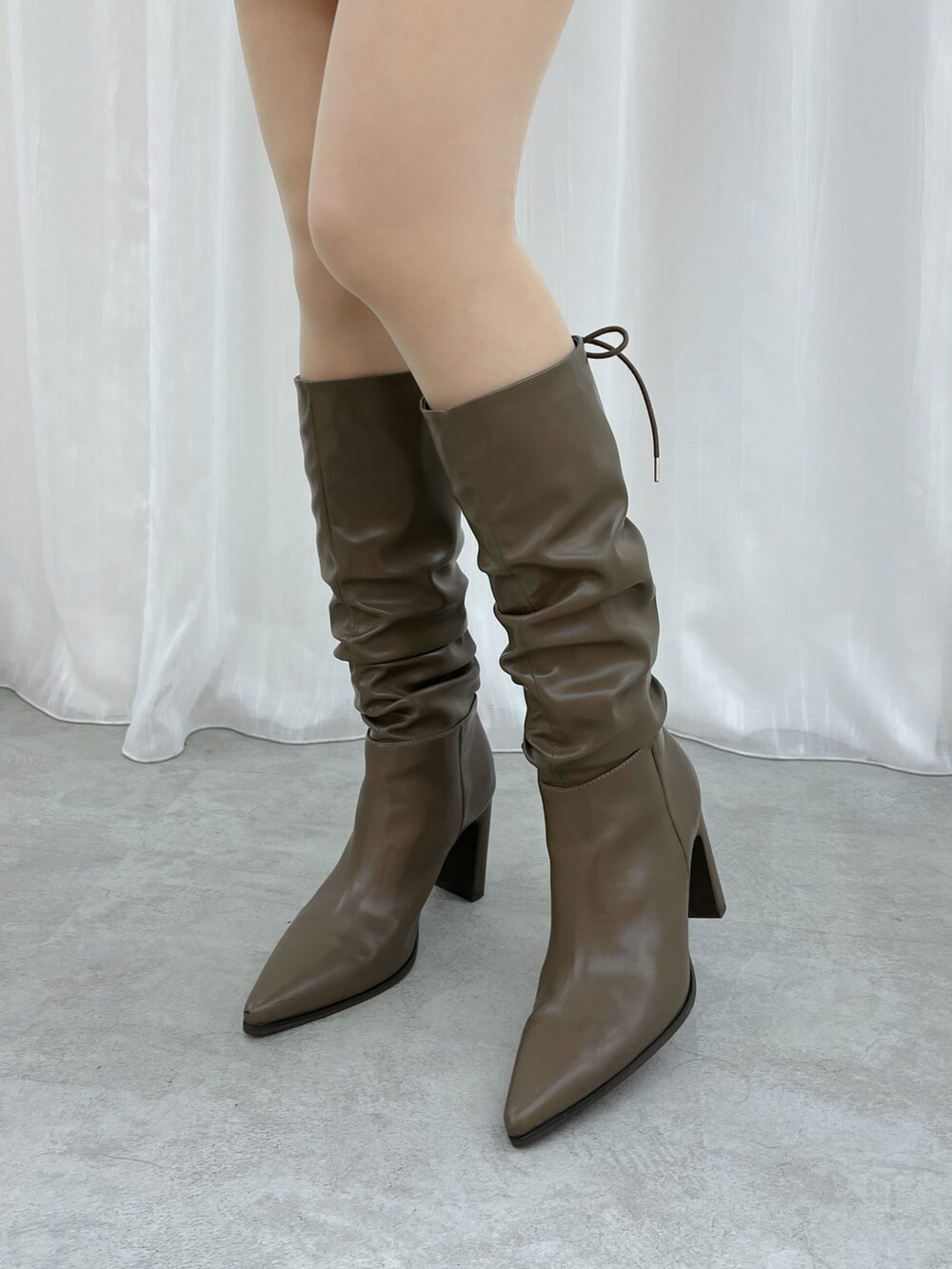 レッド系のワンピース、ブラウン系のブルゾン、ブラウン系のブーツを着用したレディースの秋コーディネートの7枚目の写真