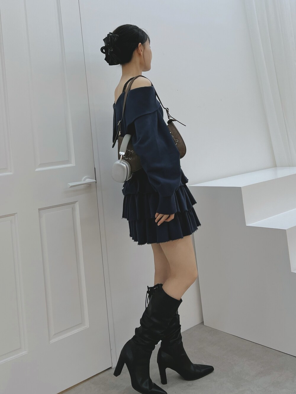 ブルー系のスカート、ブルー系のTシャツ/カットソー、ブラック系のブーツを着用したレディースの秋コーディネートの3枚目の写真