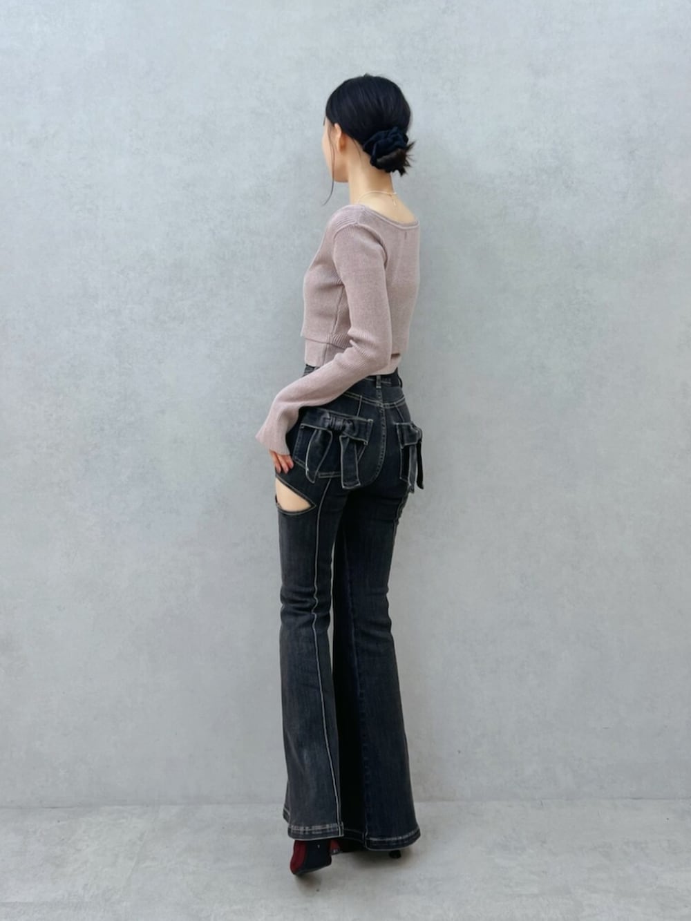 ブラック系のデニムパンツ、レッド系のブーツ、ベージュ系のニット/セーターを着用したレディースの夏コーディネートの4枚目の写真