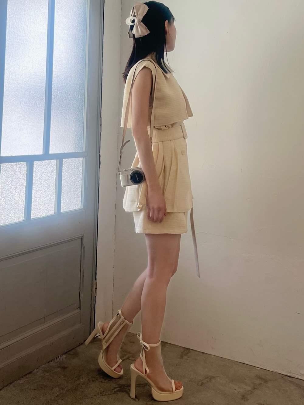 イエロー系のつなぎ/オールインワン、ホワイト系のサンダル、ピンク系のバレッタ/ヘアクリップを着用したレディースの春コーディネートの6枚目の写真