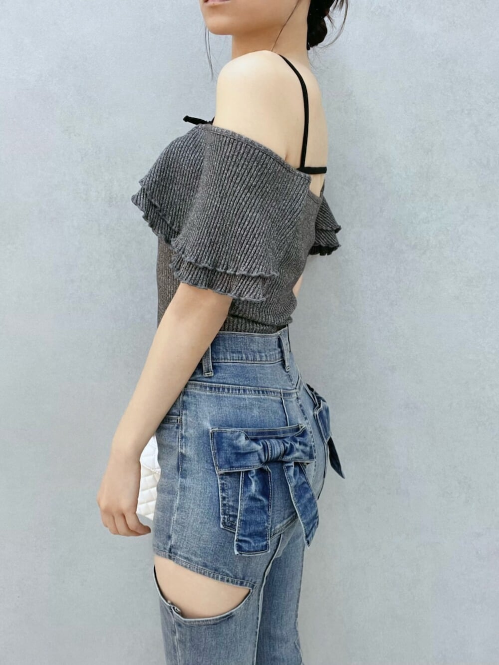 ブルー系のデニムパンツ、グレー系のTシャツ/カットソー、ホワイト系のハンドバッグを着用したレディースの夏コーディネートの7枚目の写真
