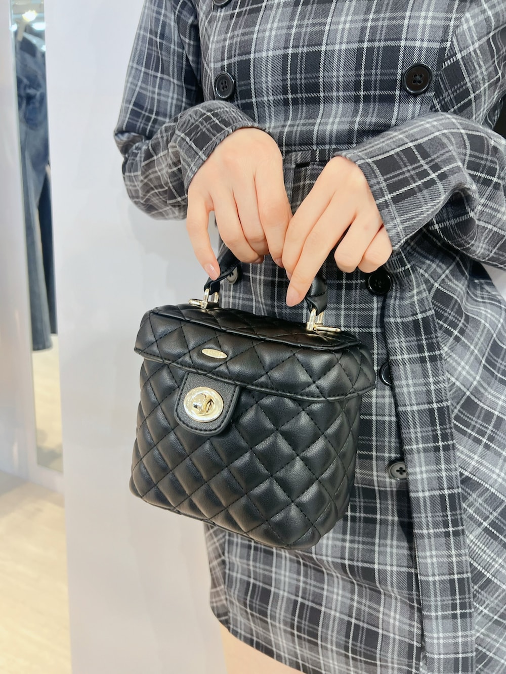 ブラック系のハンドバッグ、グレー系のワンピース、ブラック系のブーツを着用したレディースの夏コーディネートの6枚目の写真