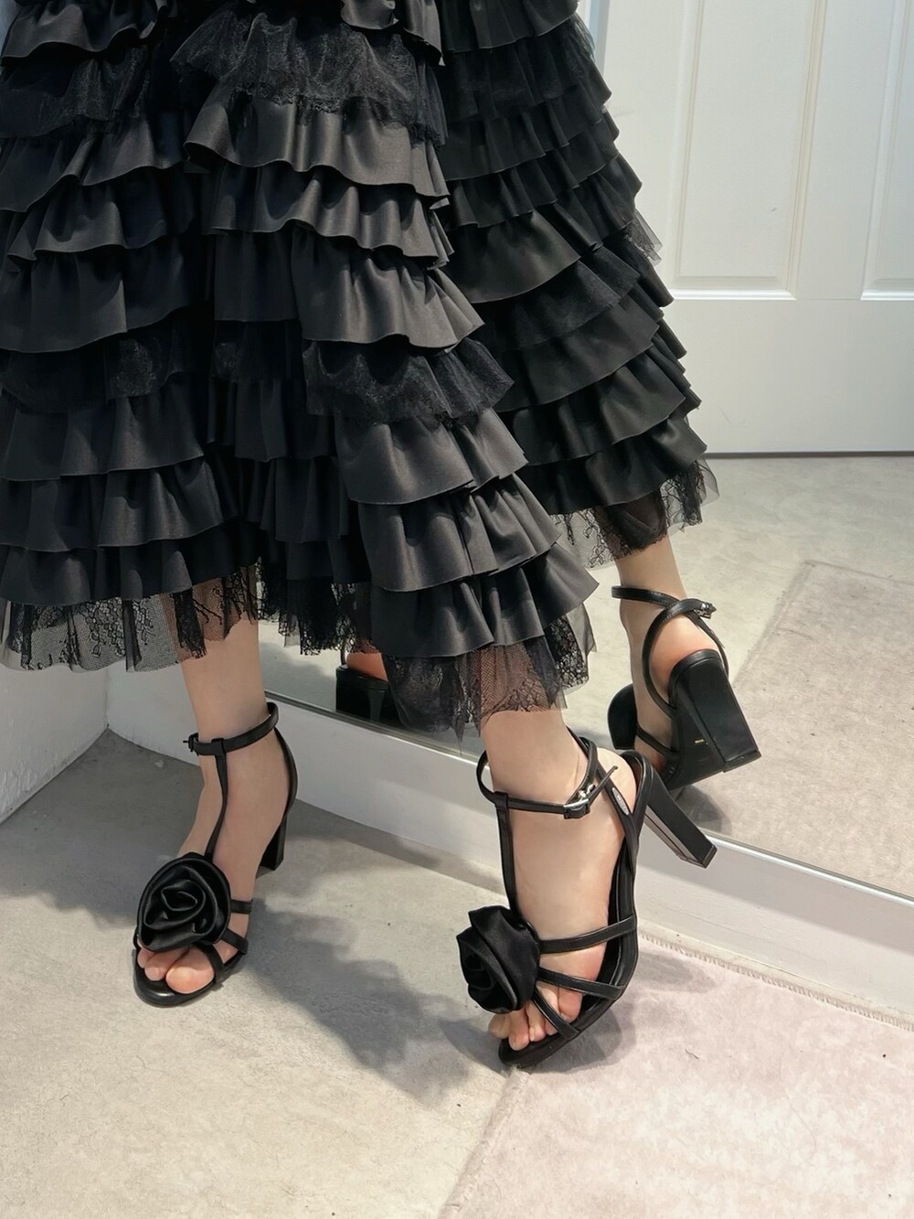 ブラック系のワンピース、ブラック系のサンダルを着用したレディースの冬コーディネートの5枚目の写真