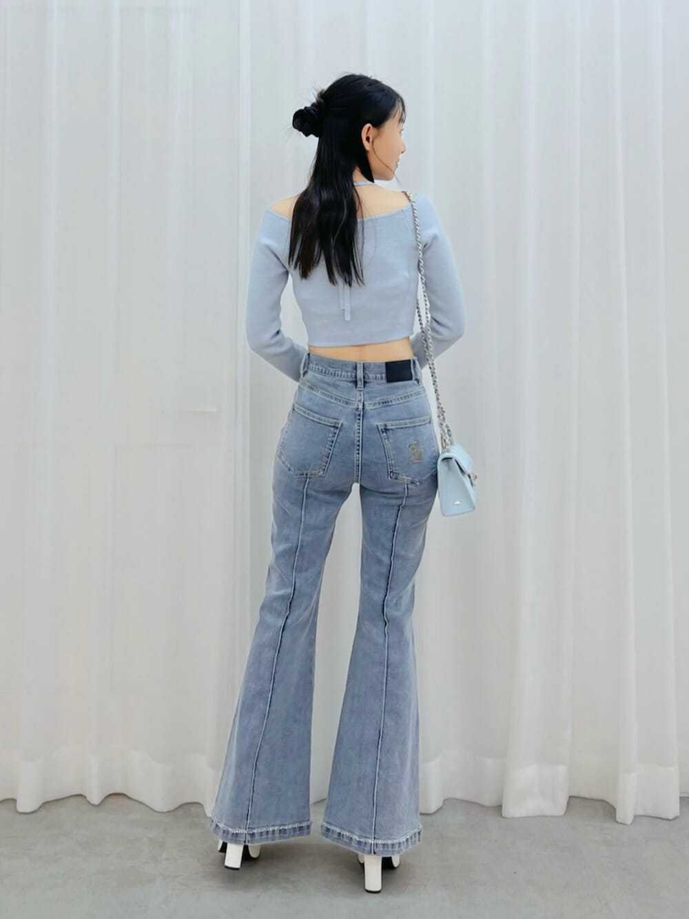 ホワイト系のブーツ、ブルー系のニット/セーター、ブルー系のデニムパンツを着用したレディースの冬コーディネートの3枚目の写真