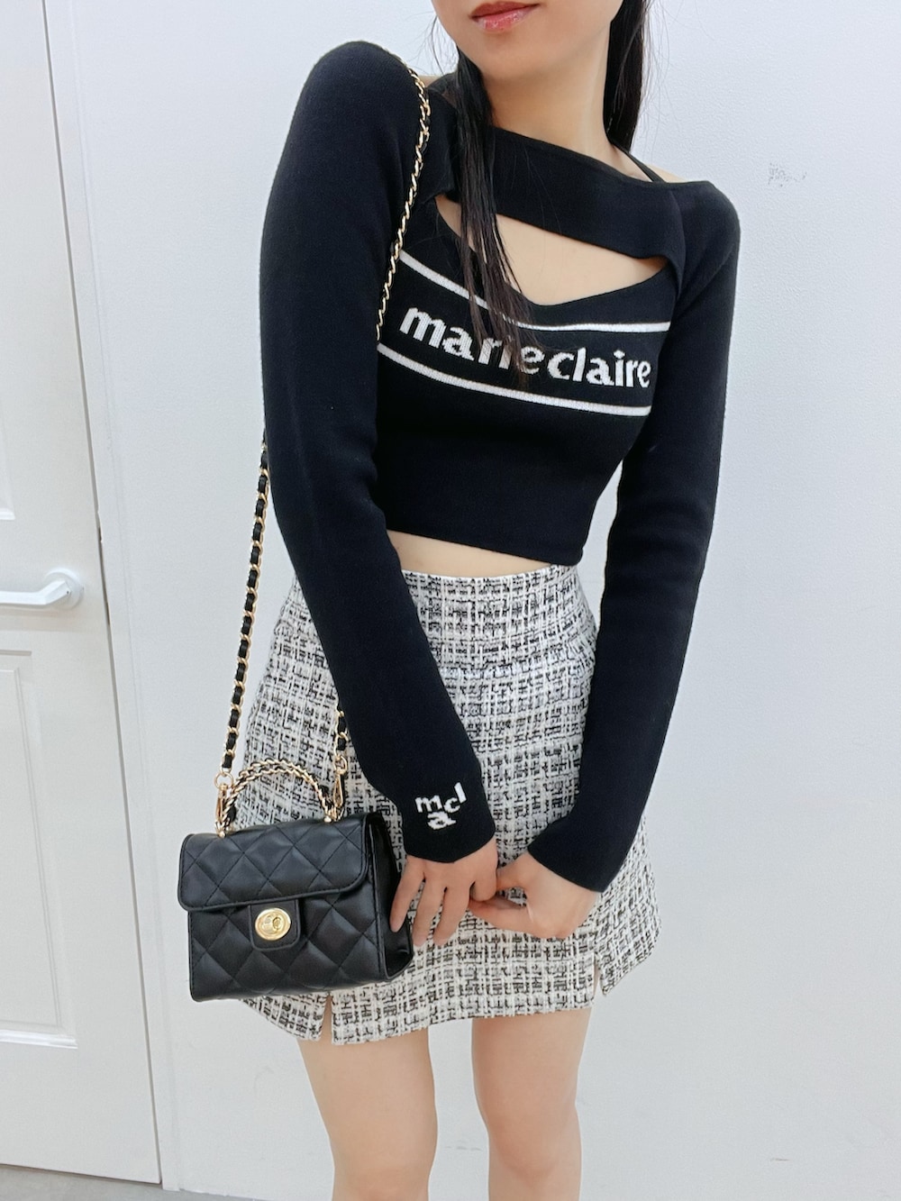 ブラック系のサンダル、ブラック系のハンドバッグ、ブラック系のスカートを着用したレディースの冬コーディネートの5枚目の写真