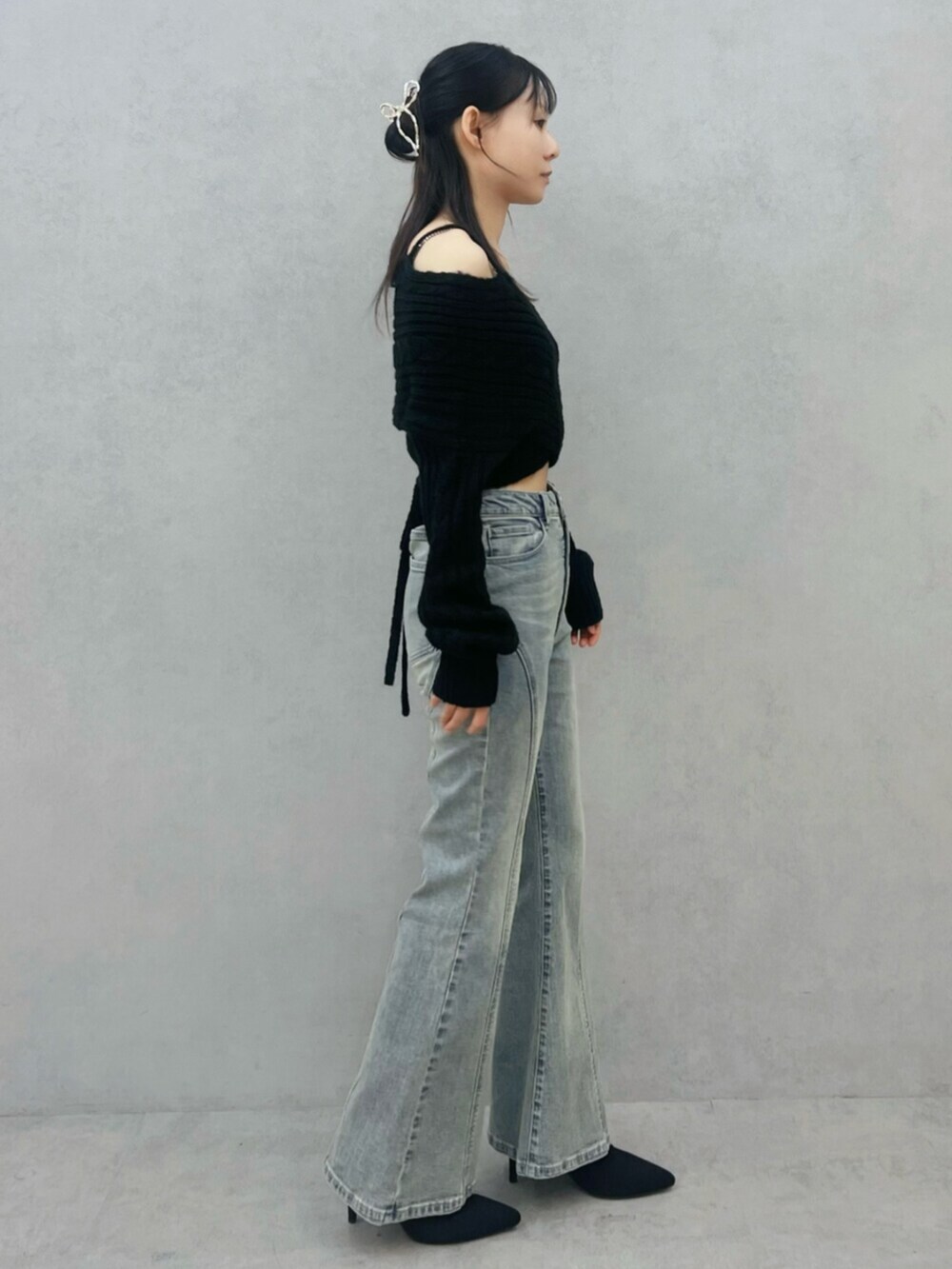 ブラック系のブーツ、ブルー系のデニムパンツ、ブラック系のニット/セーターを着用したレディースの冬コーディネートの2枚目の写真