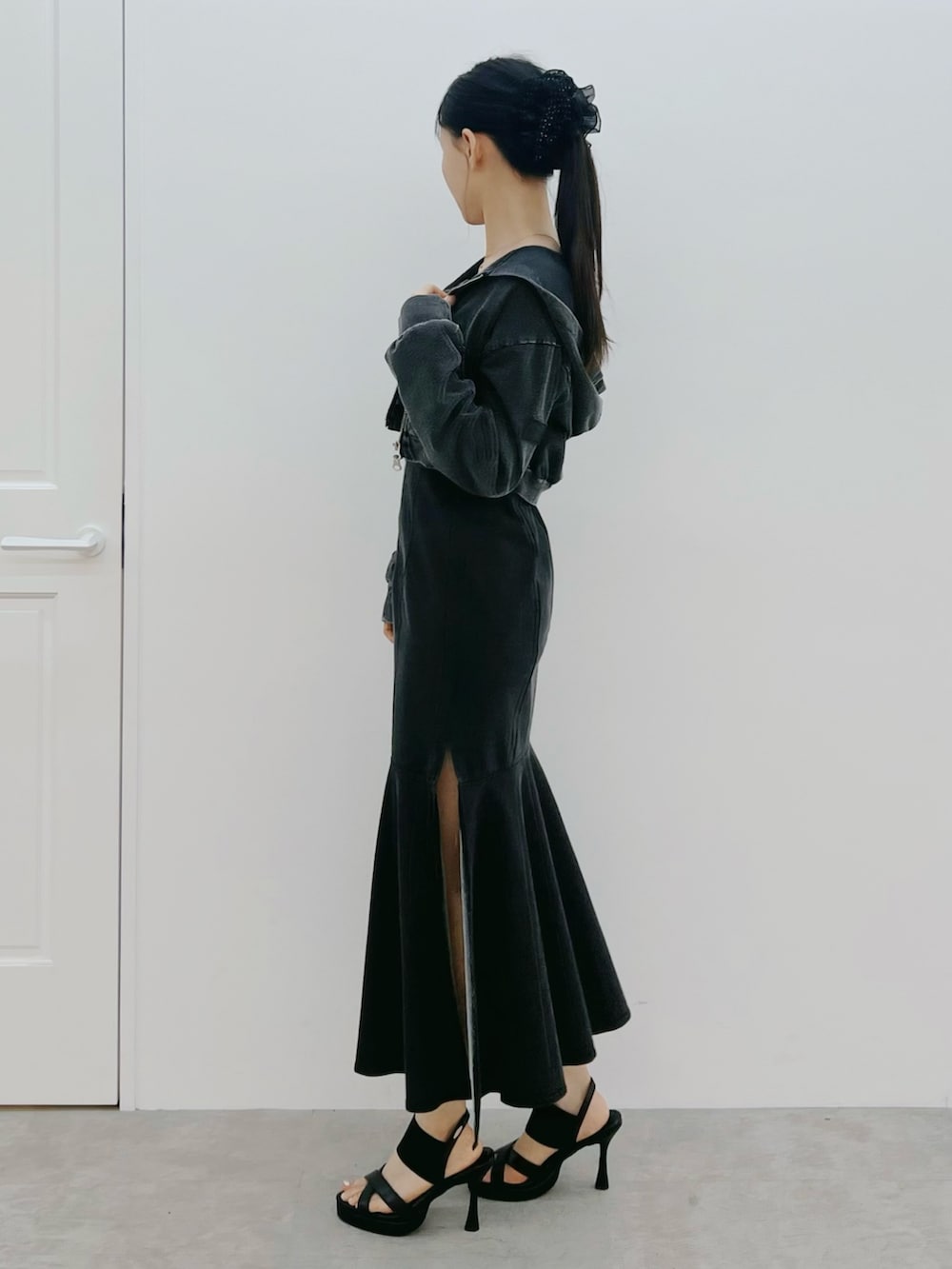 ブラック系のワンピース、ブラック系のサンダル、ブラック系のパーカーを着用したレディースの春コーディネートの2枚目の写真