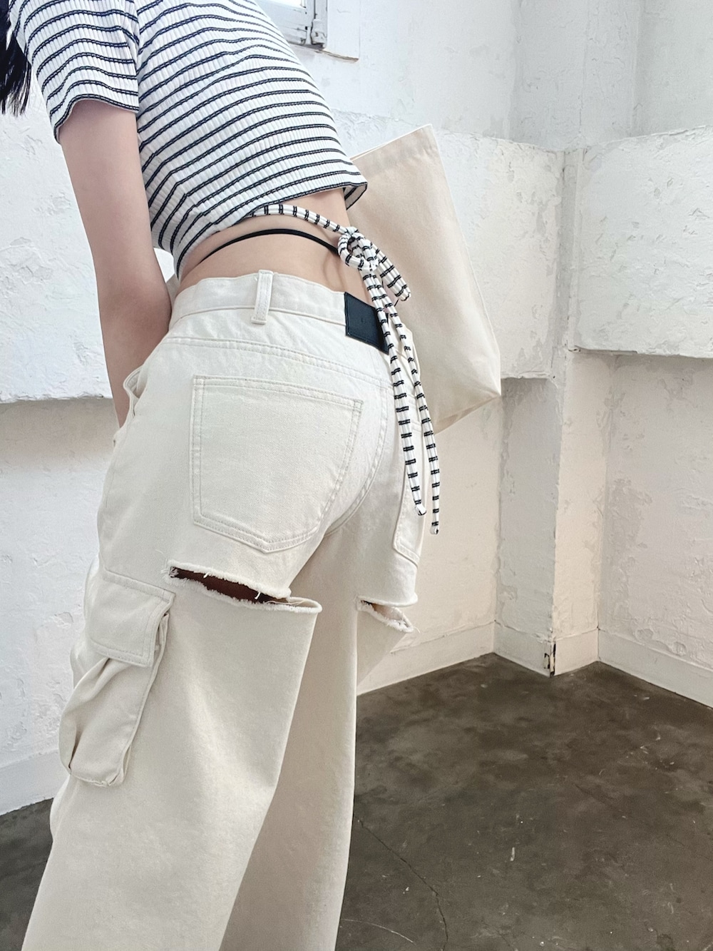 ホワイト系のデニムパンツ、その他のTシャツ/カットソー、ホワイト系のブーツを着用したレディースの春コーディネートの6枚目の写真