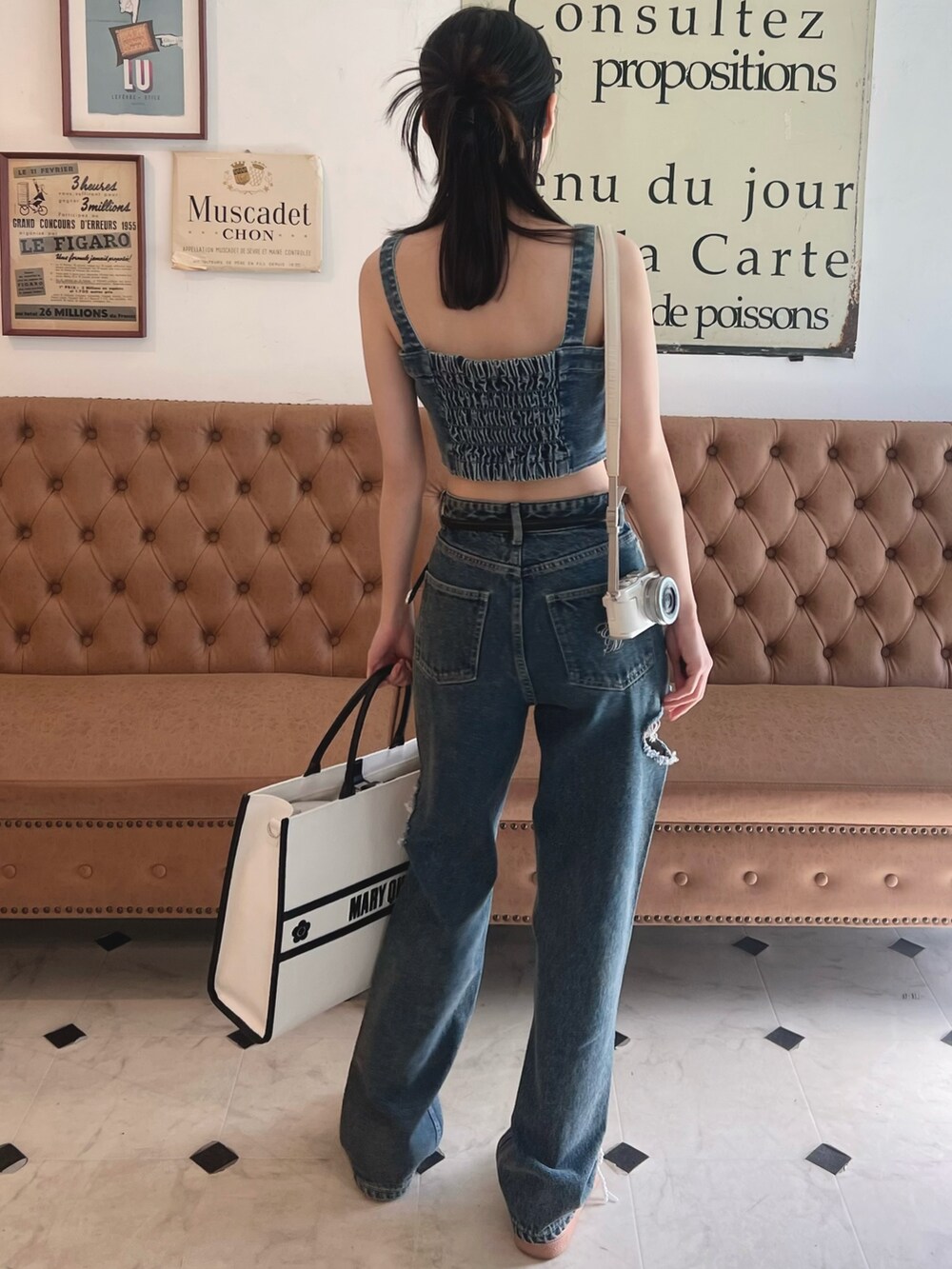 ブルー系のキャミソール、ホワイト系のトートバッグ、ブルー系のデニムパンツを着用したレディースの春コーディネートの5枚目の写真