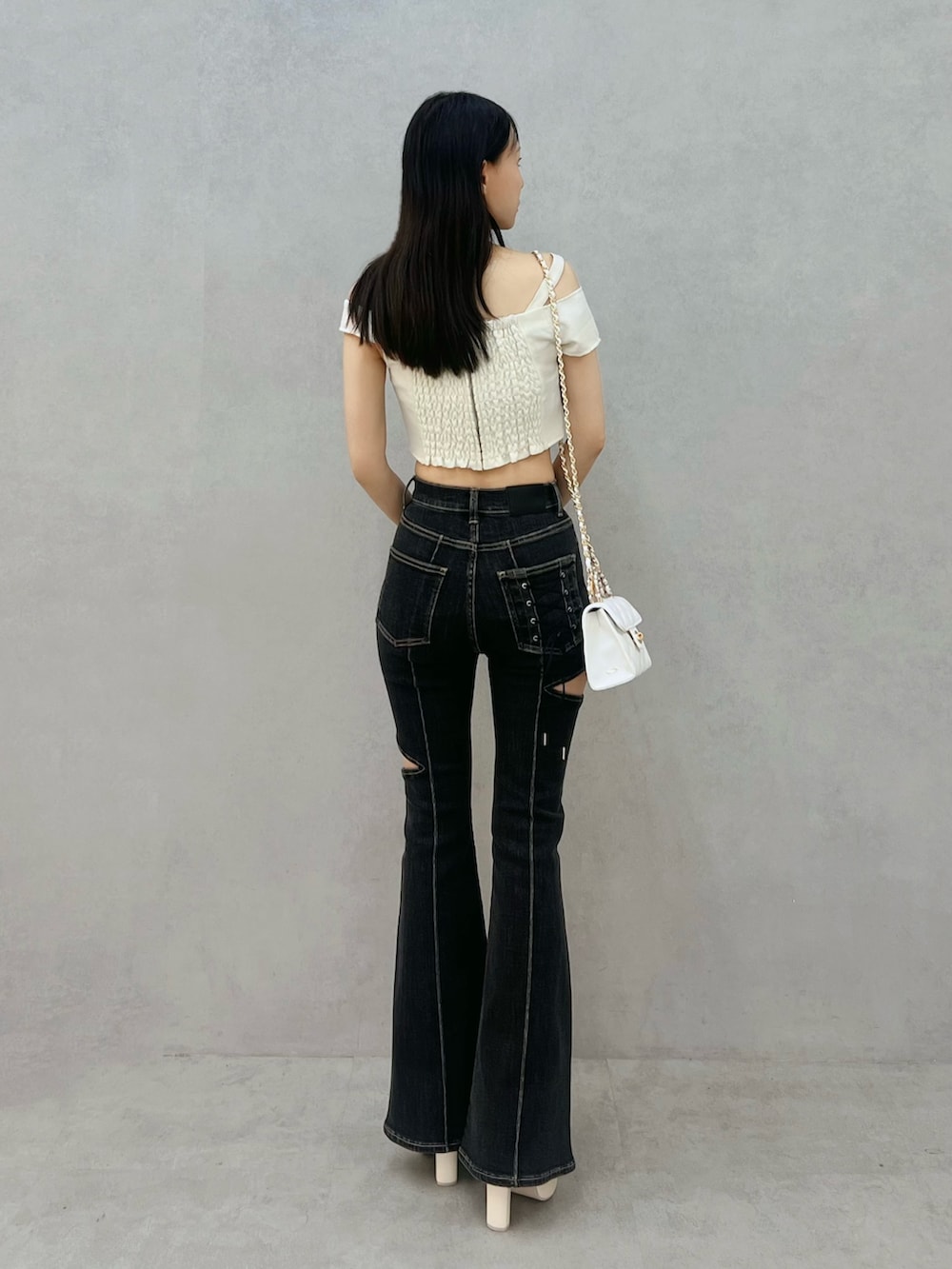 ホワイト系のハンドバッグ、ブラック系のデニムパンツ、ホワイト系のシャツ/ブラウスを着用したレディースの春コーディネートの3枚目の写真