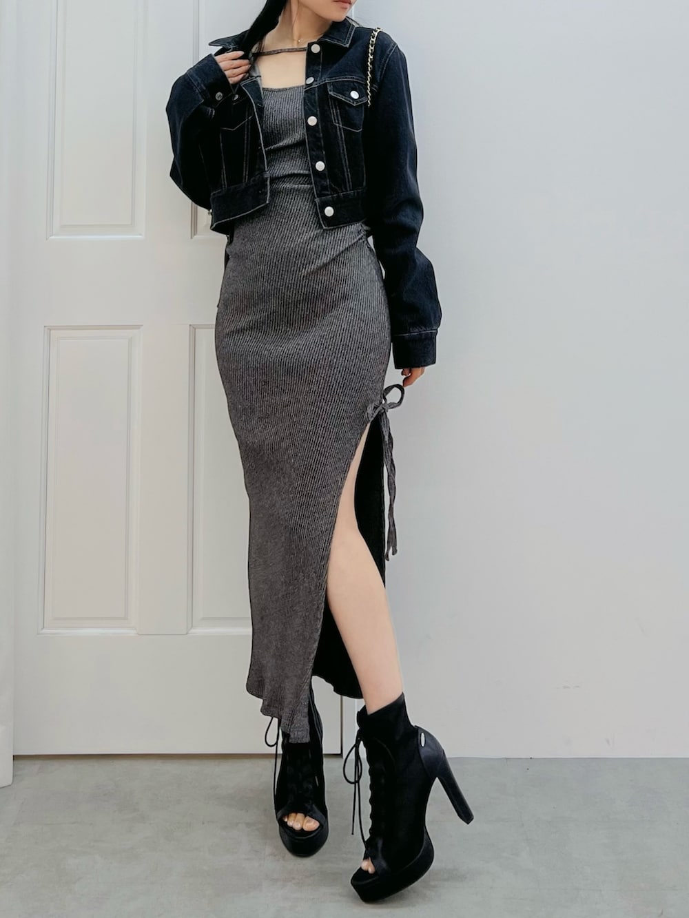 グレー系のワンピース、ブラック系のブーツ、ブラック系のデニムジャケットを着用したレディースの春コーディネートの4枚目の写真