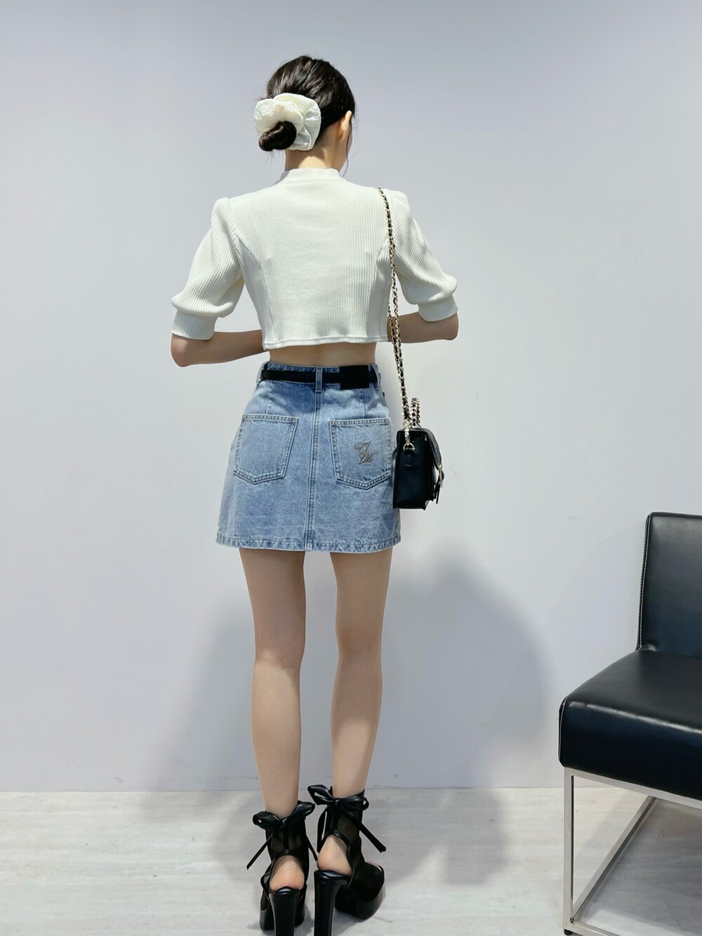 ブルー系のデニムスカート、ブラック系のサンダル、ホワイト系のTシャツ/カットソーを着用したレディースの夏コーディネートの4枚目の写真