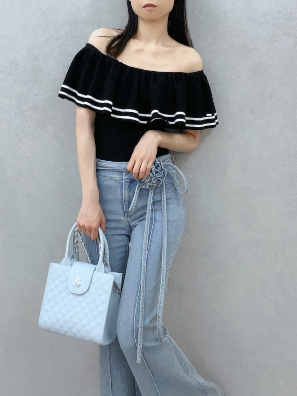 ブルー系のハンドバッグ、ブルー系のデニムパンツ、ブラック系のニット/セーターを着用したレディースの夏コーディネートの7枚目の写真