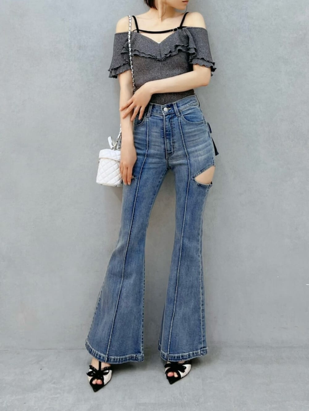 ブルー系のデニムパンツ、グレー系のTシャツ/カットソー、ホワイト系のハンドバッグを着用したレディースの夏コーディネートの4枚目の写真