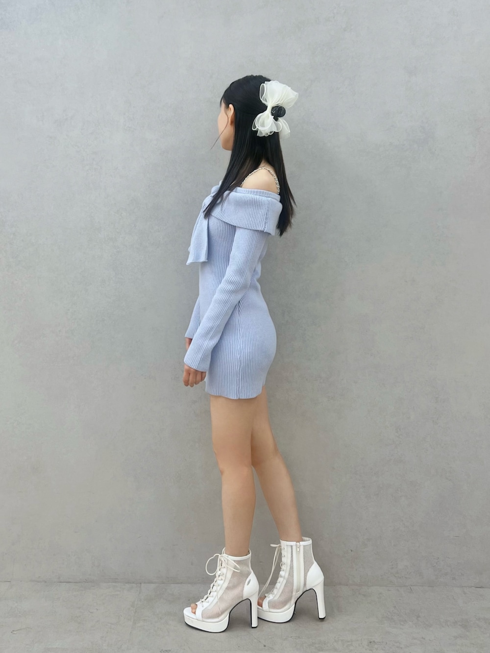 ブルー系のワンピース、ホワイト系のブーツ、ホワイト系のバレッタ/ヘアクリップを着用したレディースの冬コーディネートの2枚目の写真