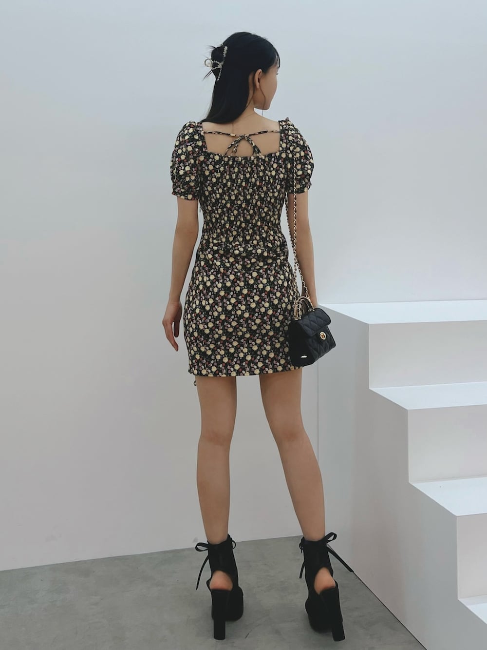 ブラック系のワンピース、ブラック系のハンドバッグ、ブラック系のサンダルを着用したレディースの春コーディネートの3枚目の写真