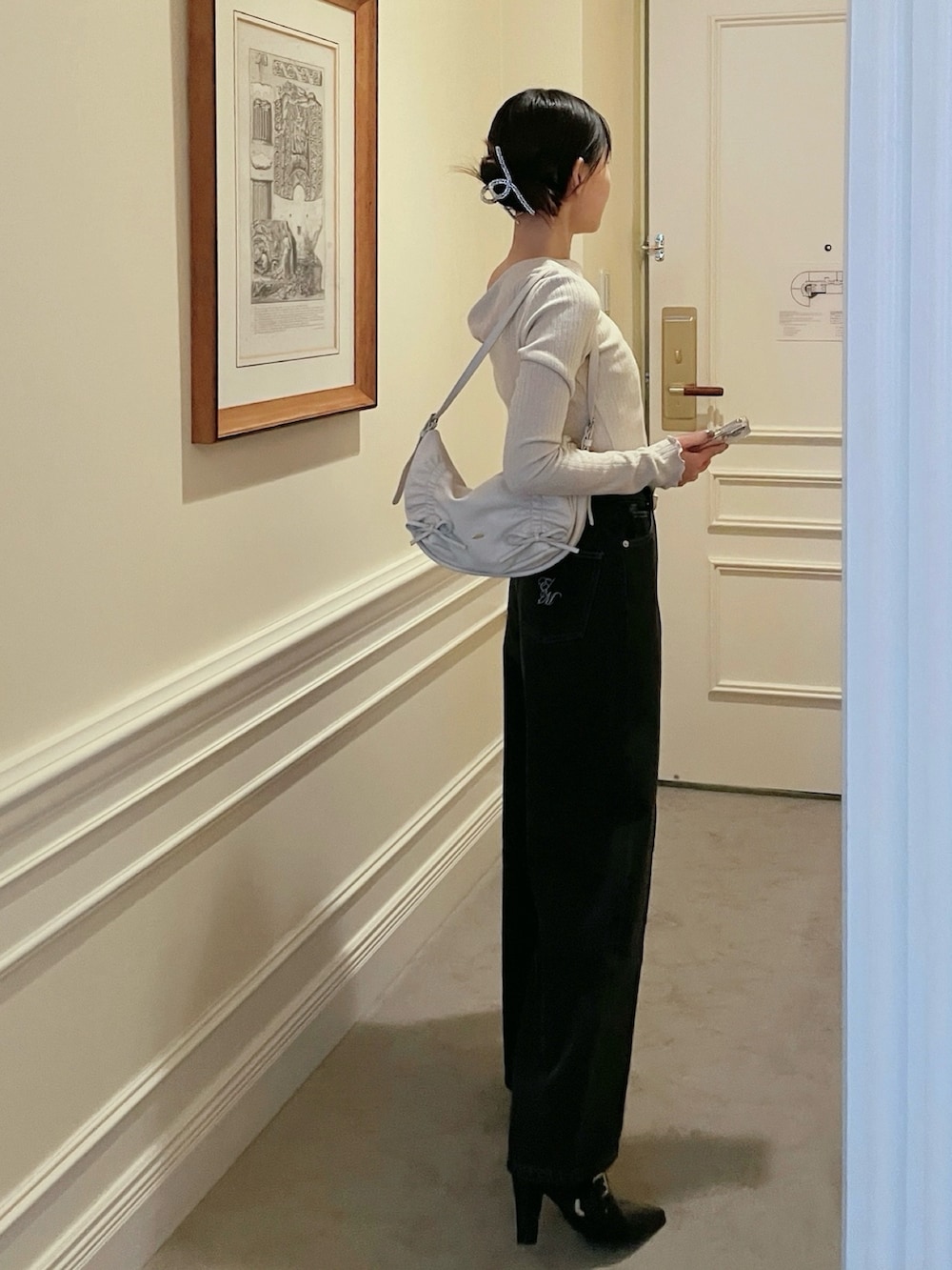 ブラック系のデニムパンツ、ホワイト系のショルダーバッグ、ホワイト系のTシャツ/カットソーを着用したレディースの冬コーディネートの2枚目の写真