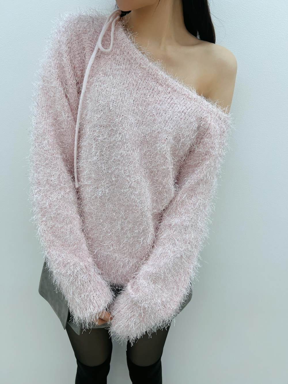 グレー系のスカート、ブラック系のブーツ、ピンク系のニット/セーターを着用したレディースの冬コーディネートの5枚目の写真