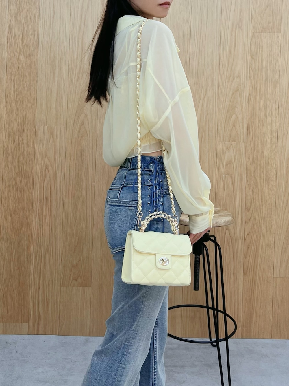 ホワイト系のサンダル、ブルー系のデニムパンツ、イエロー系のハンドバッグを着用したレディースの春コーディネートの6枚目の写真